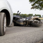 Motorcycle Accident between a silver car an black motorcycle. Filing a Dallas Motorcycle Accident Claim with No Helmet