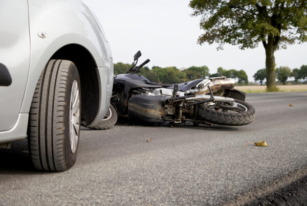 Motorcycle Accident between a silver car an black motorcycle. Filing a Dallas Motorcycle Accident Claim with No Helmet