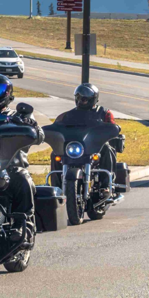 Motorcyclists riding on a scenic road, wondering is lane splitting legal in Texas?