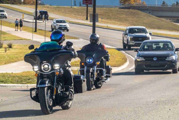 Motorcyclists riding on a scenic road, wondering is lane splitting legal in Texas?
