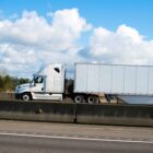 Camión blanco circulando por la autopista, mostrando las rutas de transporte por carretera más peligrosas de Dallas.