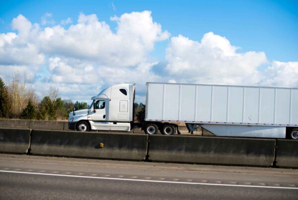 Camión blanco circulando por la autopista, mostrando las rutas de transporte por carretera más peligrosas de Dallas.
